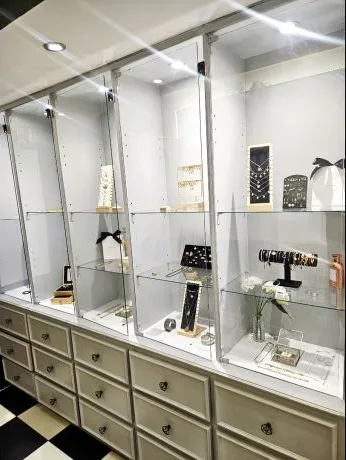 Les vitrines de bijoux du shop, meubles à tiroirs et sol en damier